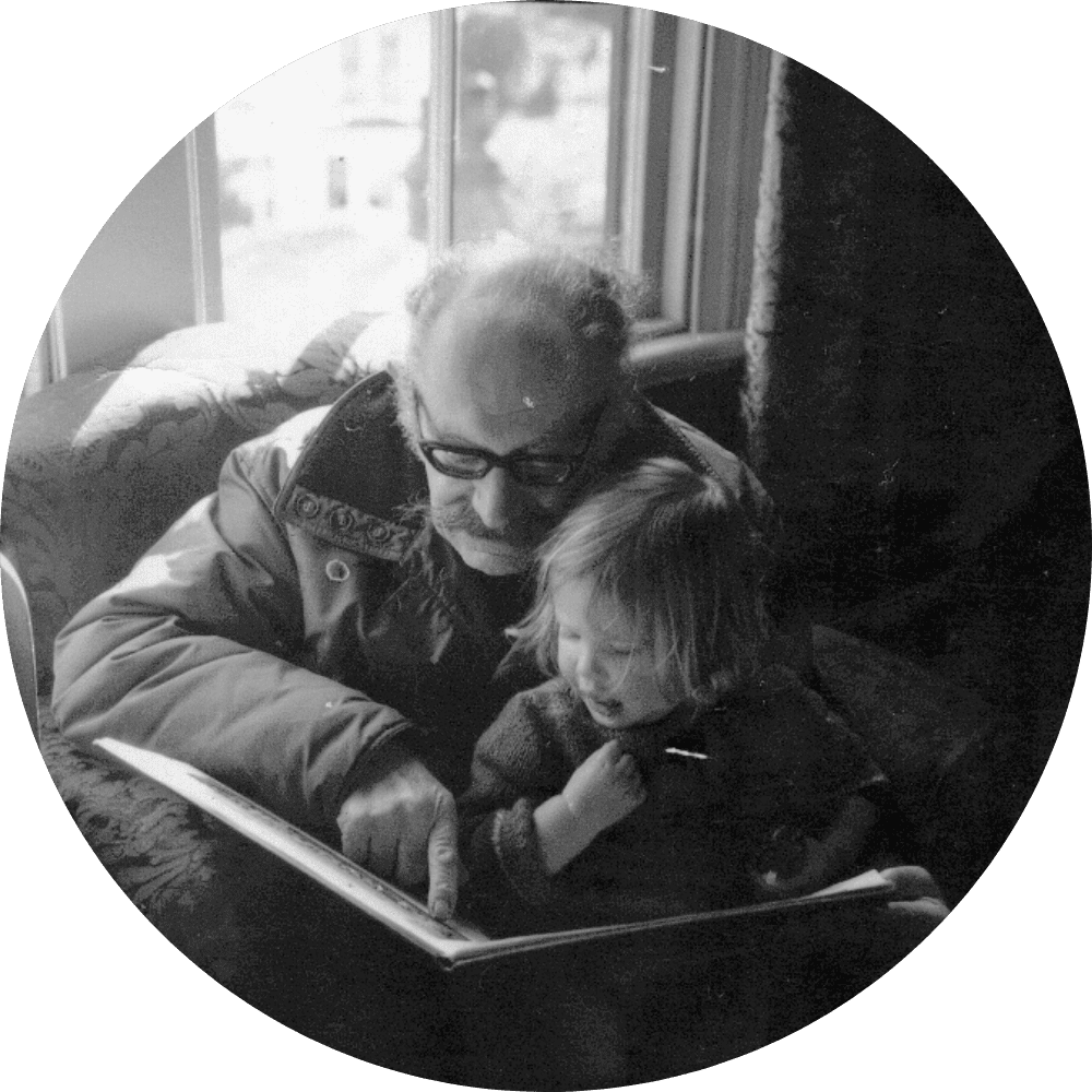 An old black and white family photo of my geologist grandfather Burton reading to me.